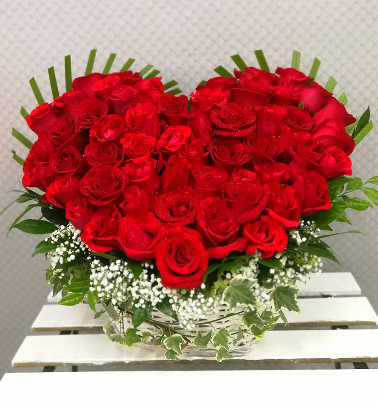 heart shaped arrangement of red roses in basket