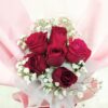 red roses in a pink hand bouquet