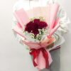 red roses in a pink hand bouquet